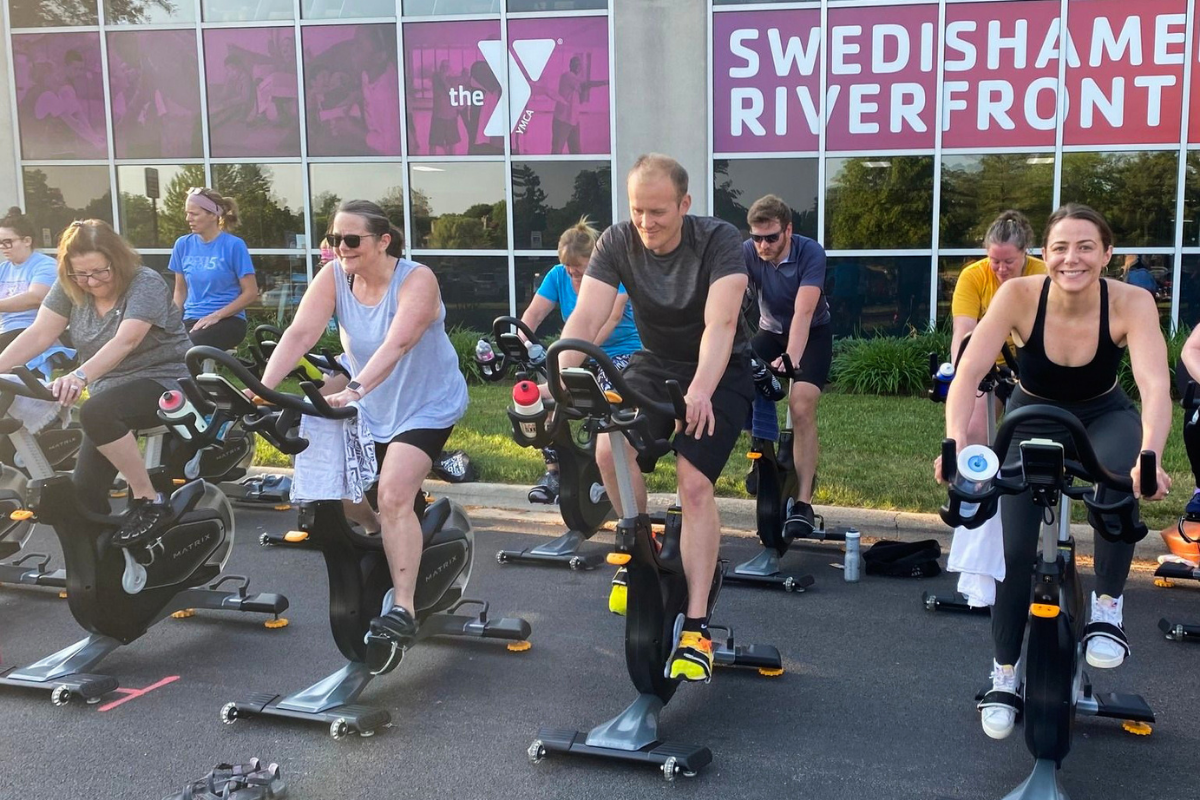 Group of individuals on cycling bikes riding outdoors