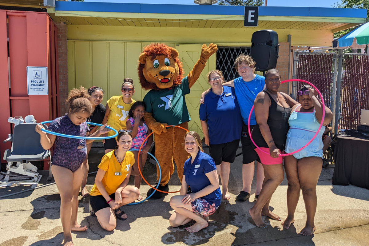 Group of kids and adults posing for a picture at a pool party