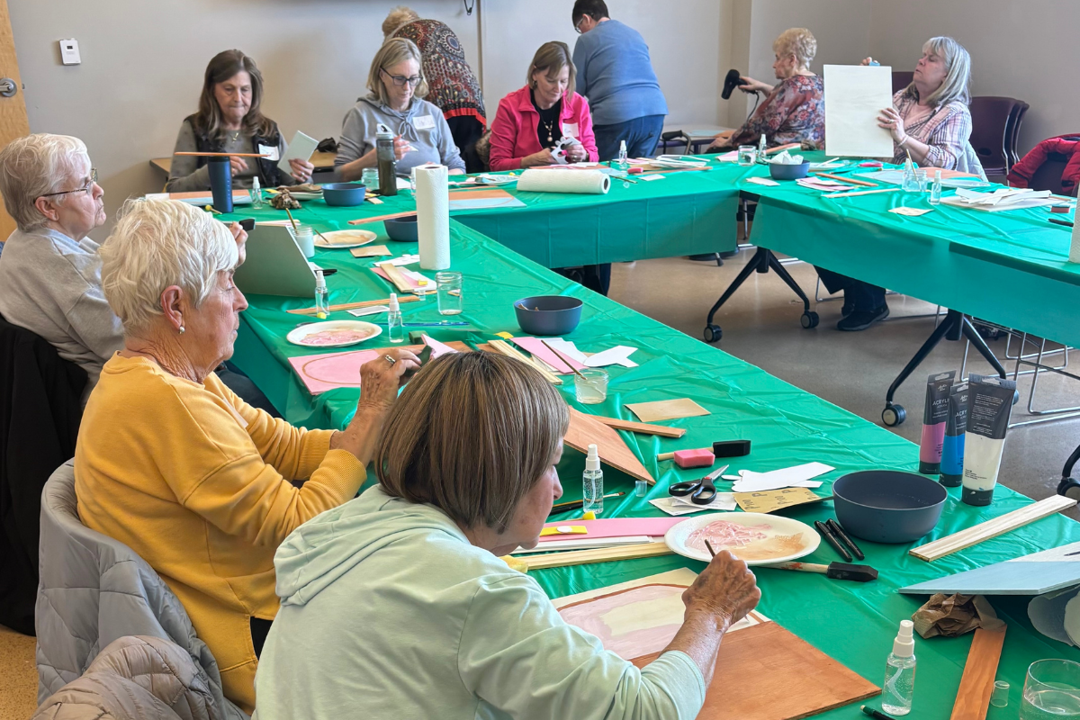 Group of women sitting around a table crafting