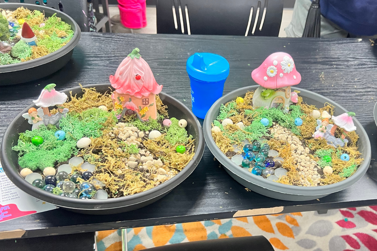 Two colorful fairy gardens on a table side by side