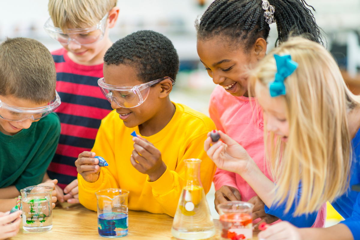Group of youth conduct an experiment with science beakers.