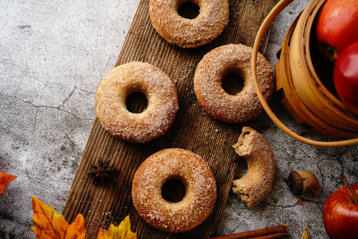 Bucket of apple and apple cider donuts displayed on a table.