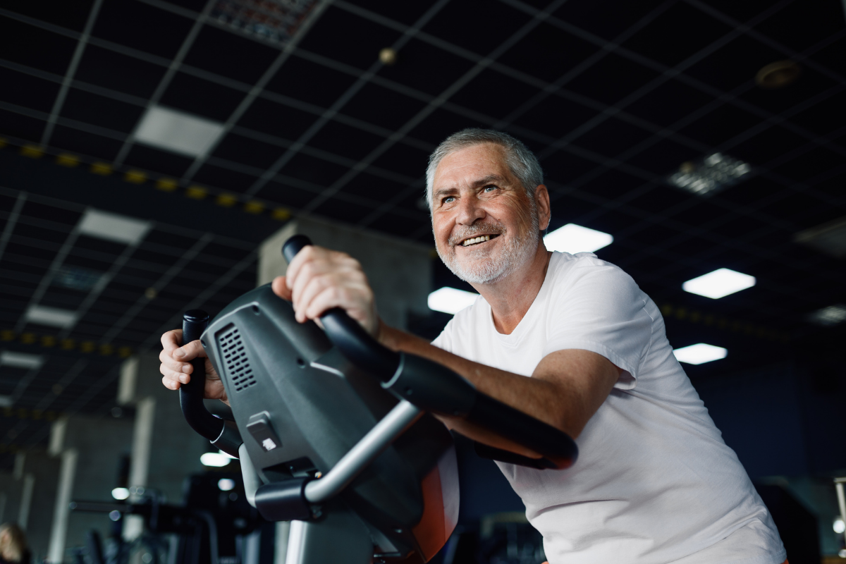 Older adult on stationary bike smiling
