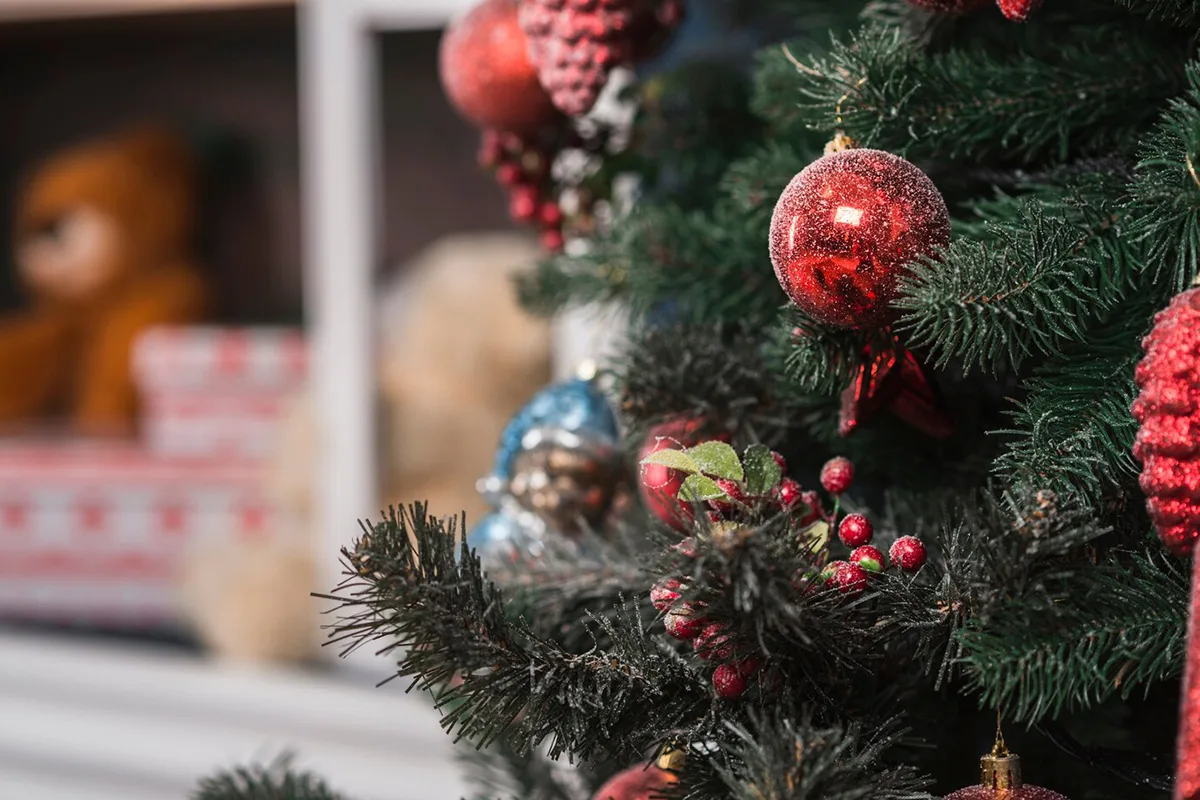 Close-up of decorated Christmas tree with red ornaments and holiday decorations.